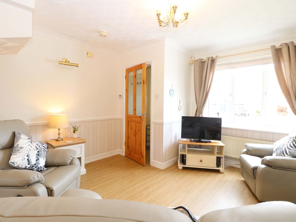 A living room with sofas and a television at Breydon Cottage in Bradwell near Gorleston-On-Sea