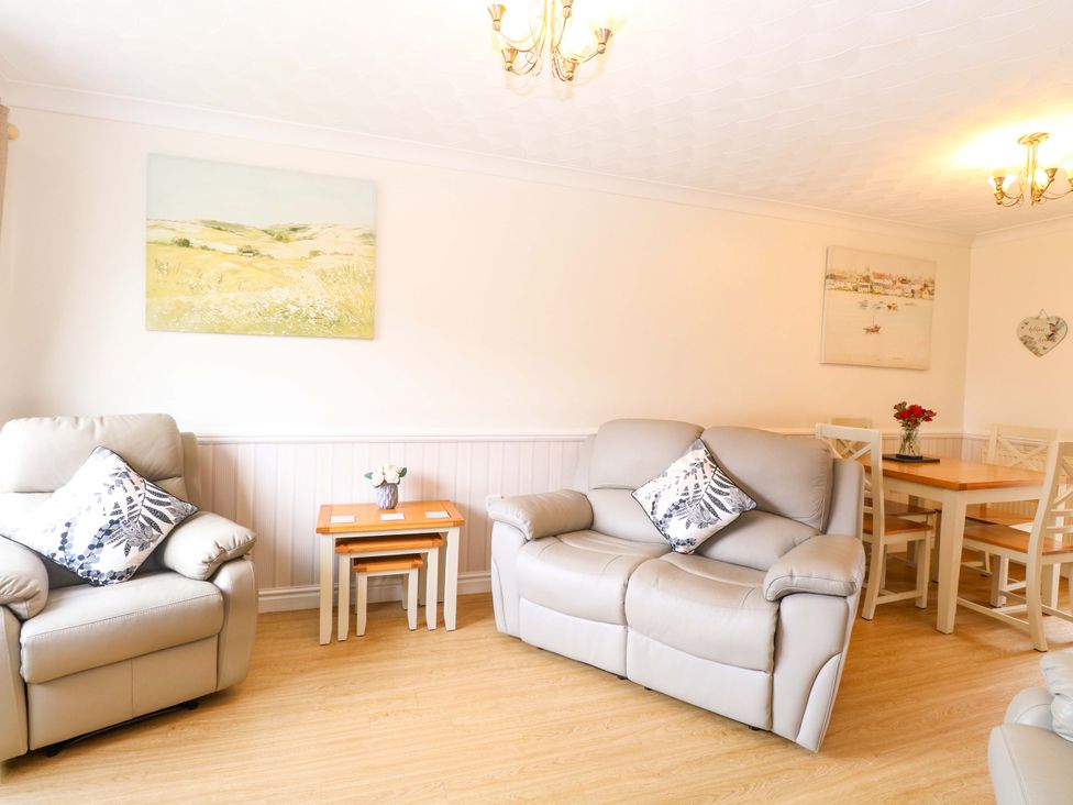 A living room with a sofa and dining area at Breydon Cottage in Bradwell near Gorleston-On-Sea