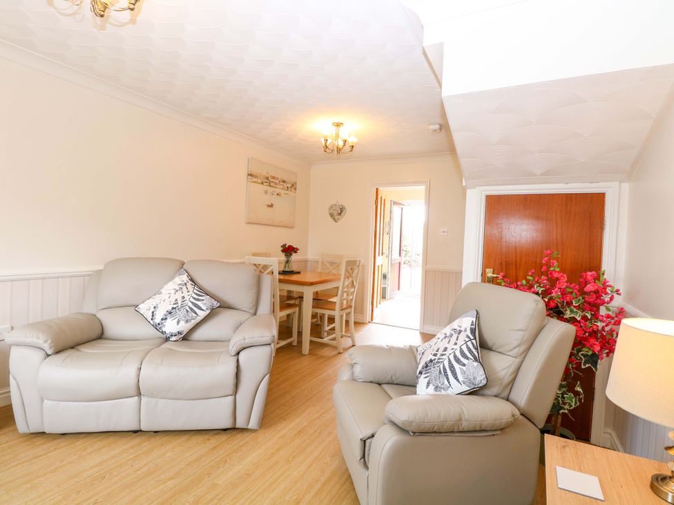 A living room with sofa and dining area at Breydon Cottage Bradwell near Gorleston-On-Sea