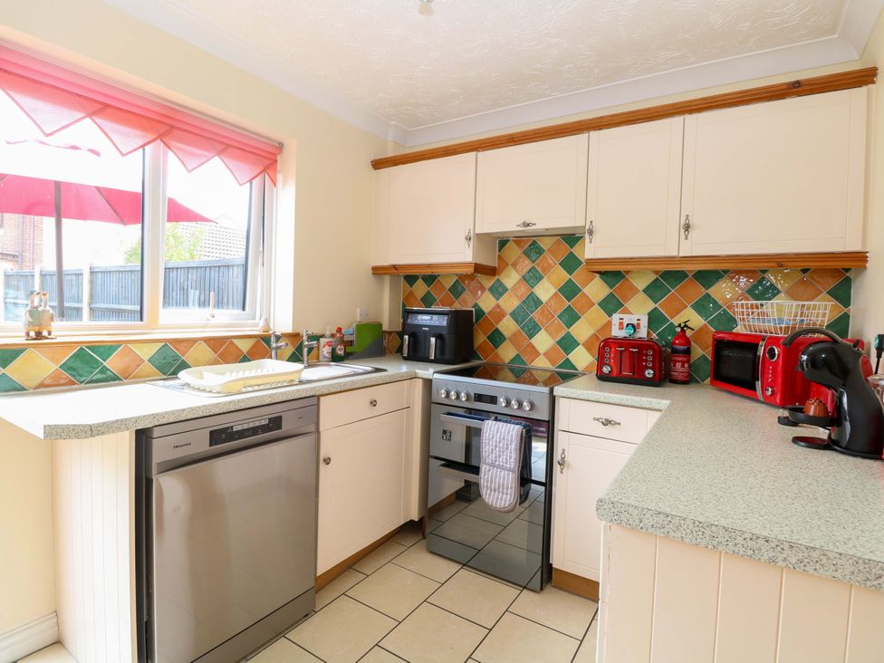 A kitchen with various appliances and sink at Breydon Cottage in Bradwell near Gorleston-On-Sea