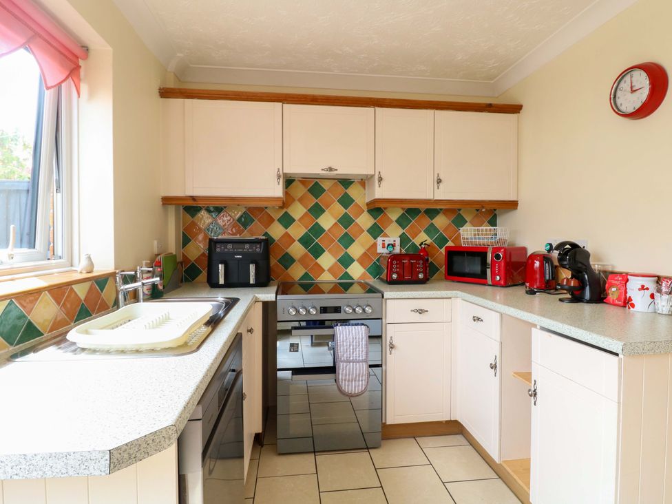 A kitchen with appliances and countertop at Breydon Cottage in Bradwell near Gorleston-On-Sea