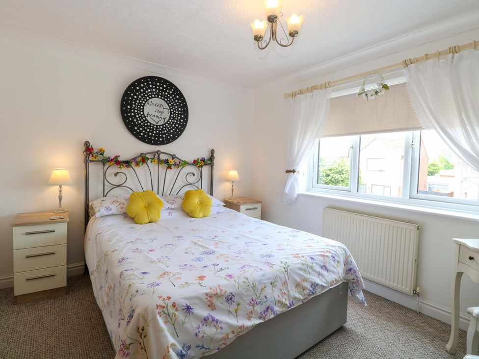 A bedroom with a bed, bedside tables and lamps at Breydon Cottage, Bradwell near Gorleston-On-Sea