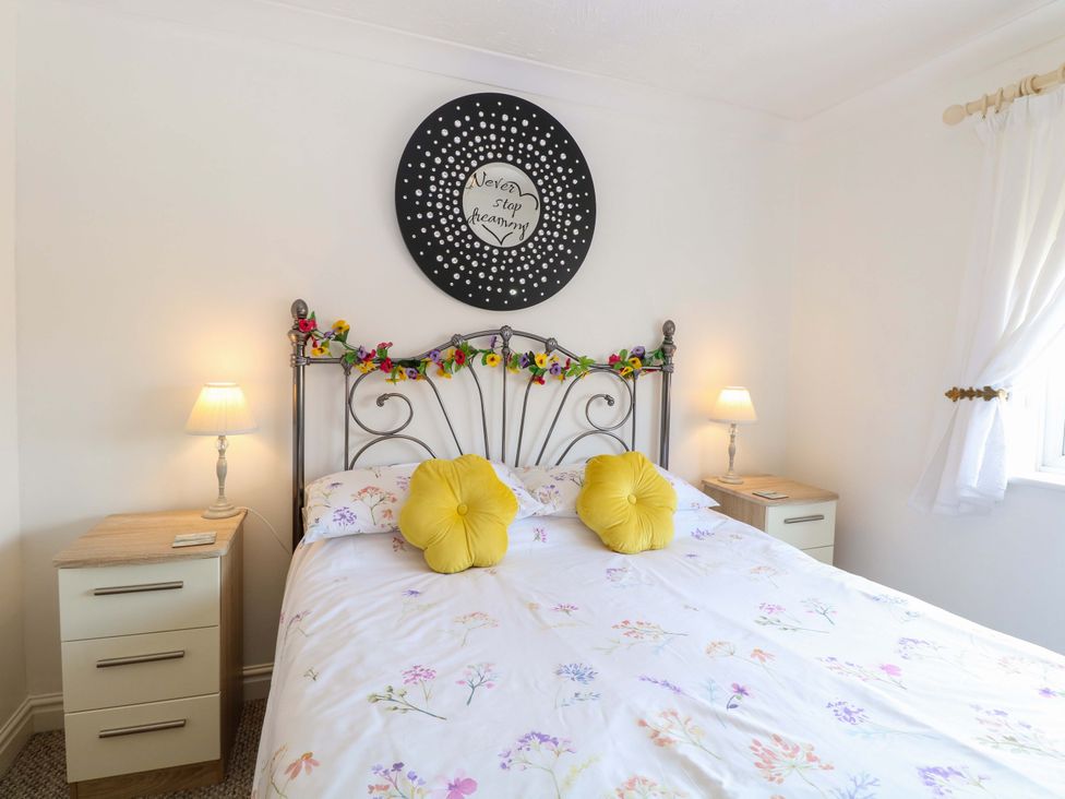 A bedroom with a bed and bedside lamps at Breydon Cottage in Bradwell near Gorleston-On-Sea