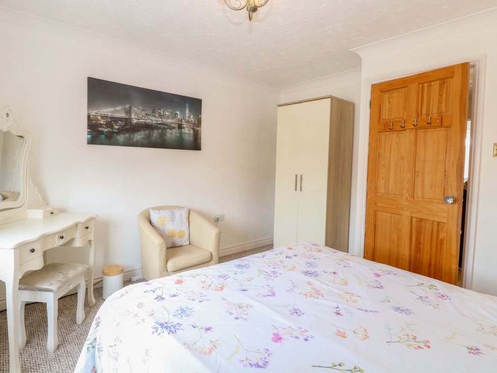 A bedroom with a wardrobe and dressing table at Breydon Cottage in Bradwell near Gorleston-On-Sea
