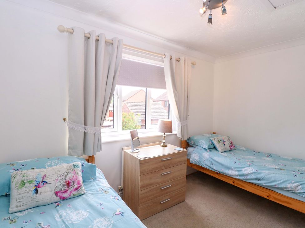 A bedroom with two beds and a window at Breydon Cottage, Bradwell near Gorleston-On-Sea