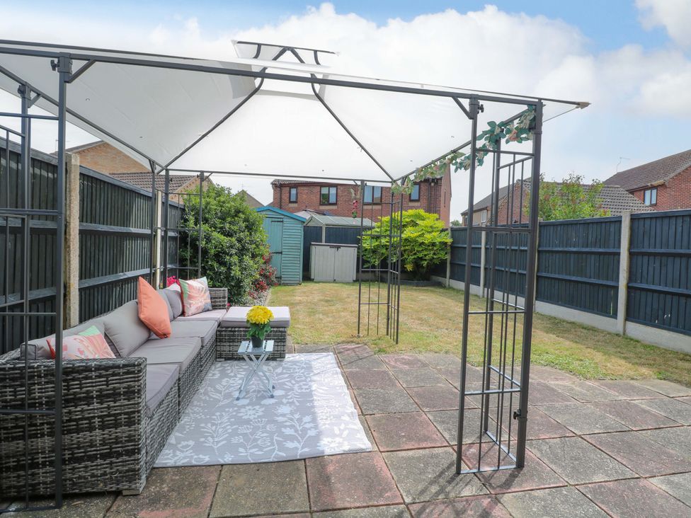A garden with a canopy and seating area at Breydon Cottage in Bradwell near Gorleston-On-Sea