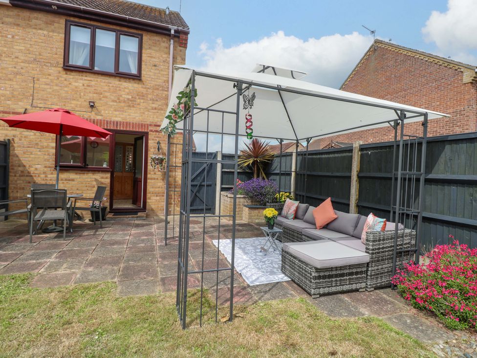 A garden with outdoor seating and a patio at Breydon Cottage in Bradwell near Gorleston-On-Sea