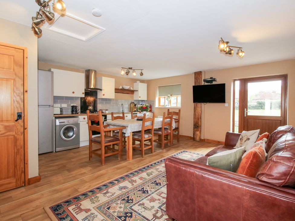 A kitchen and dining area with seating and appliances at Old Hall Barn 2 Church Stretton