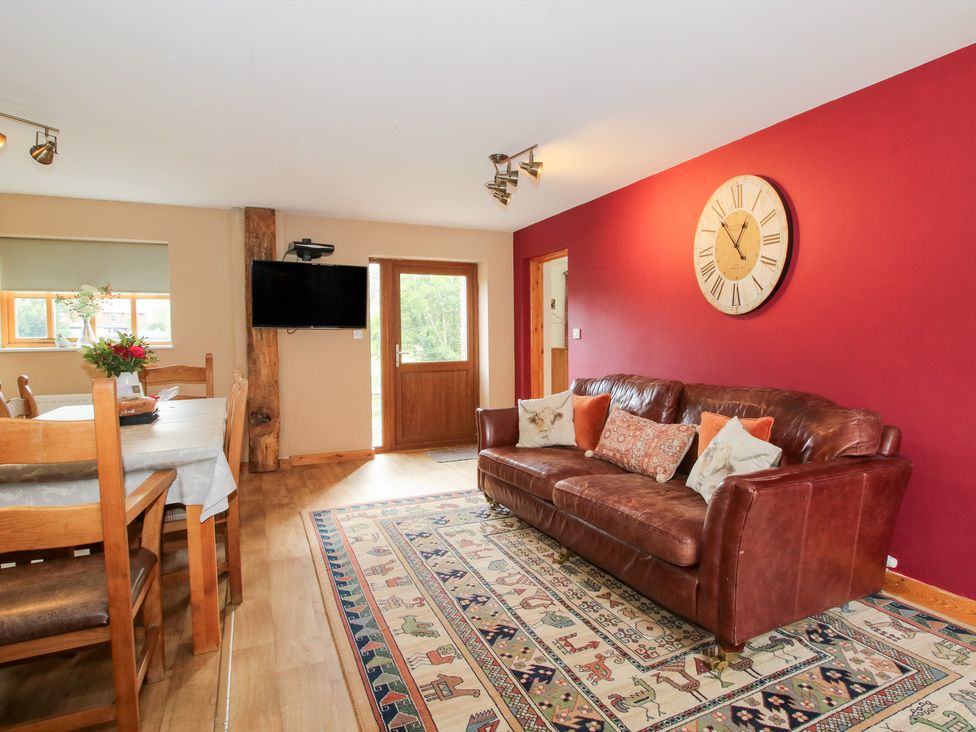 A living room with a sofa and dining table at Old Hall Barn 2 Church Stretton