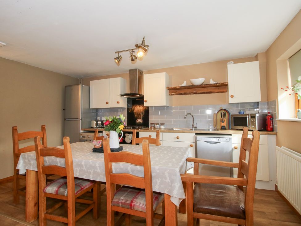 A kitchen with a dining table and chairs at Old Hall Barn 2 Church Stretton