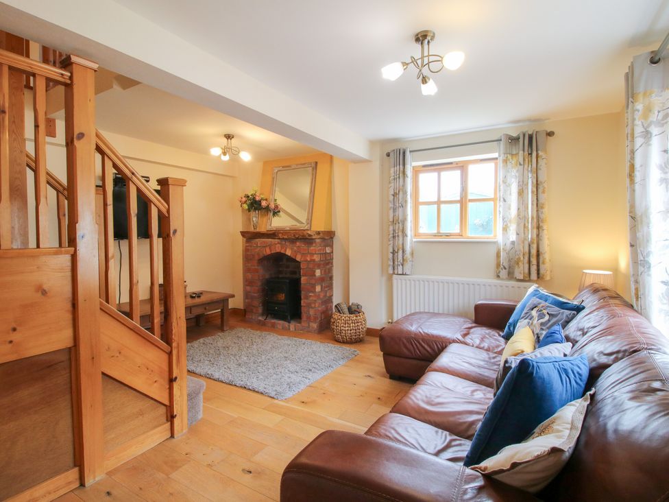 A living room with a sofa and a fireplace at Old Hall Barn 2 in Church Stretton