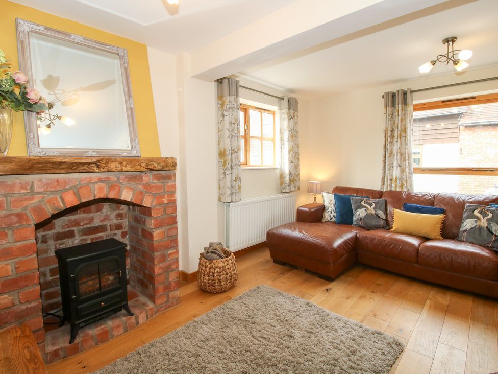 A living room with a sofa and fireplace at Old Hall Barn 2 Church Stretton