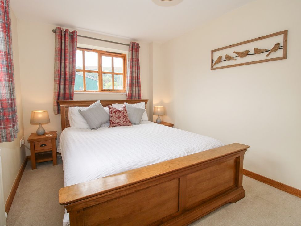 A bedroom with a bed and window at Old Hall Barn 2 Church Stretton