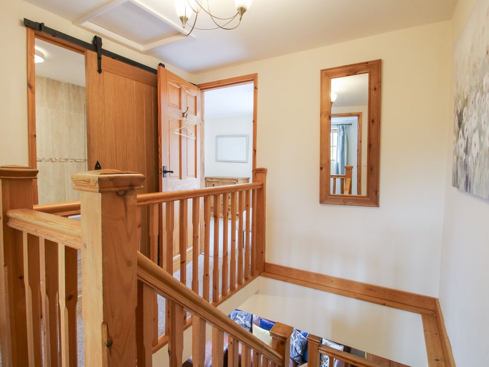 A hallway with a staircase and doors at Old Hall Barn 2 Church Stretton