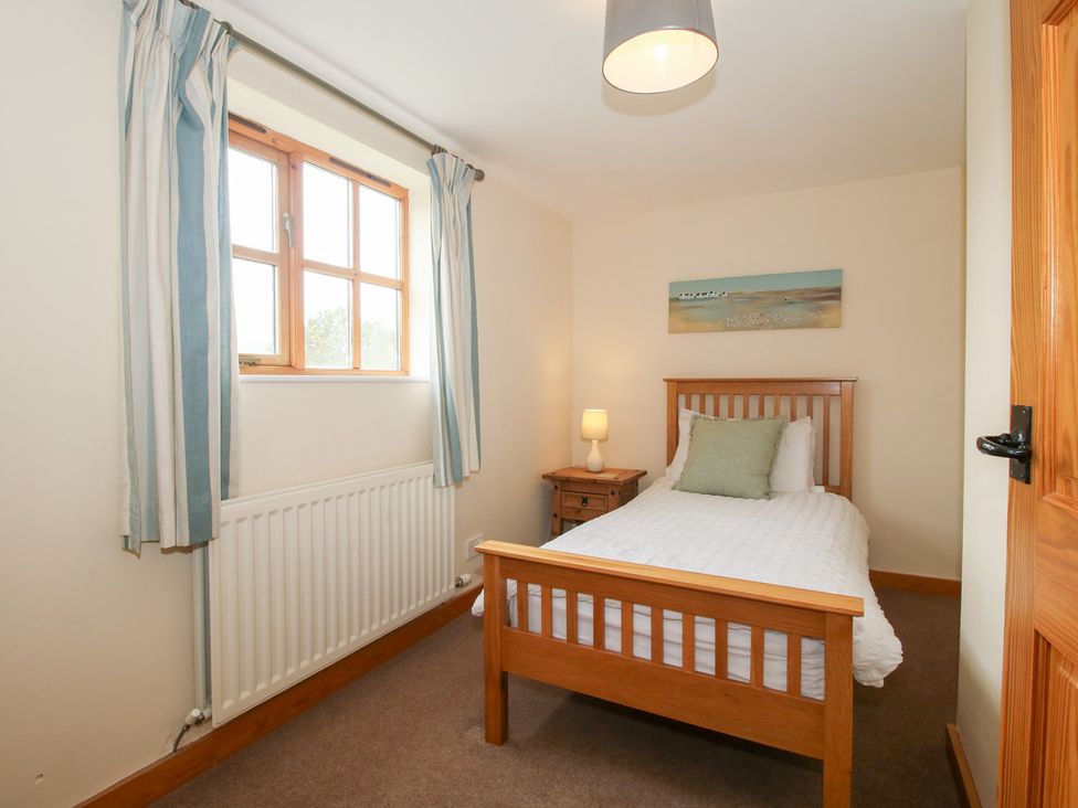 A bedroom with a single bed and window at Old Hall Barn 2 Church Stretton