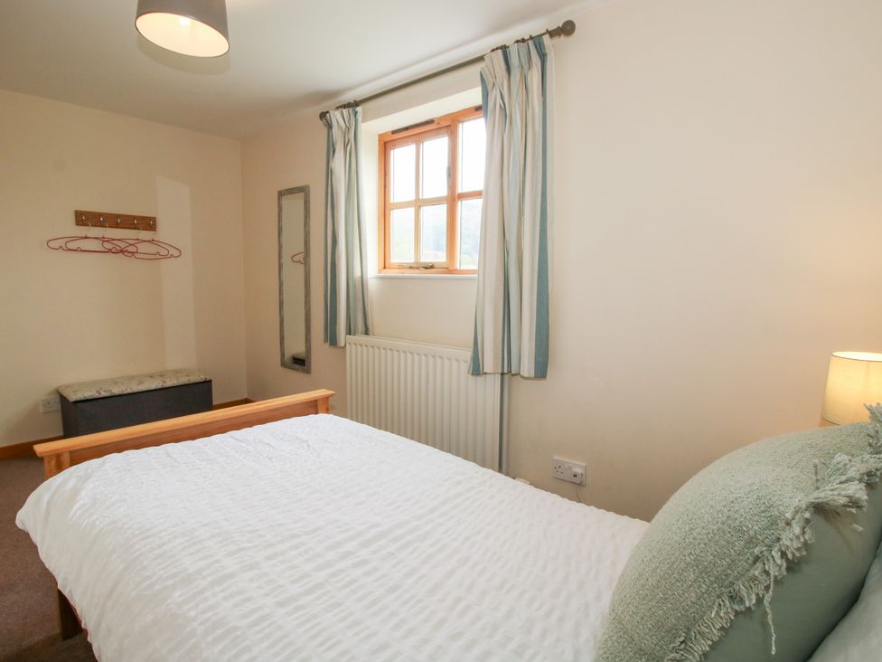 A bedroom with a bed and window at Old Hall Barn 2 Church Stretton