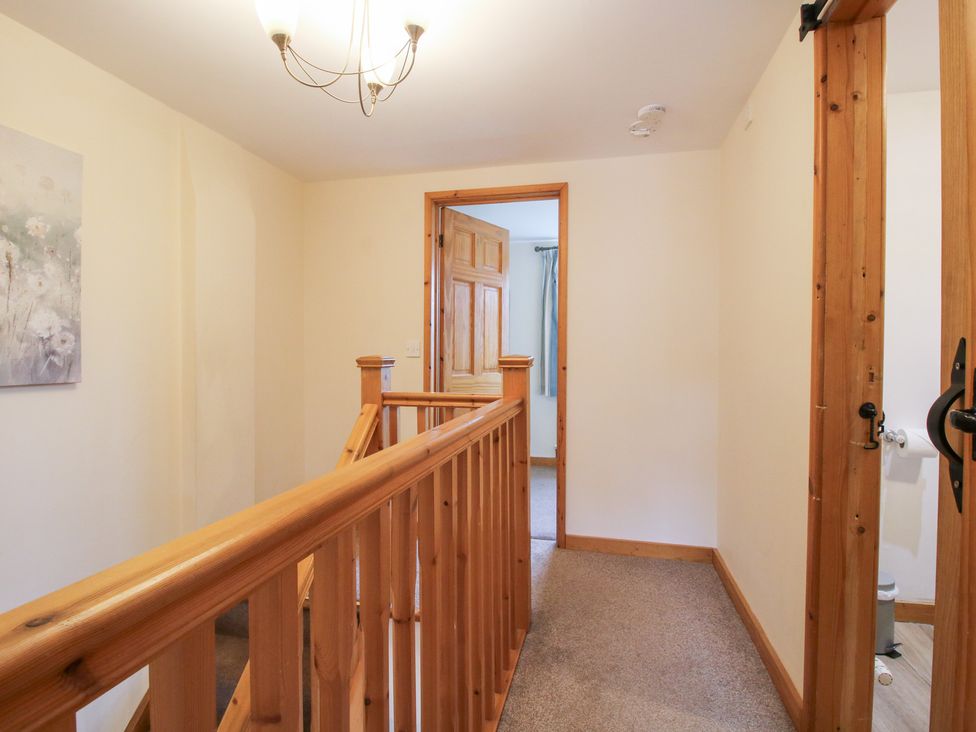 A hallway with wooden railing and doors at Old Hall Barn 2, Church Stretton