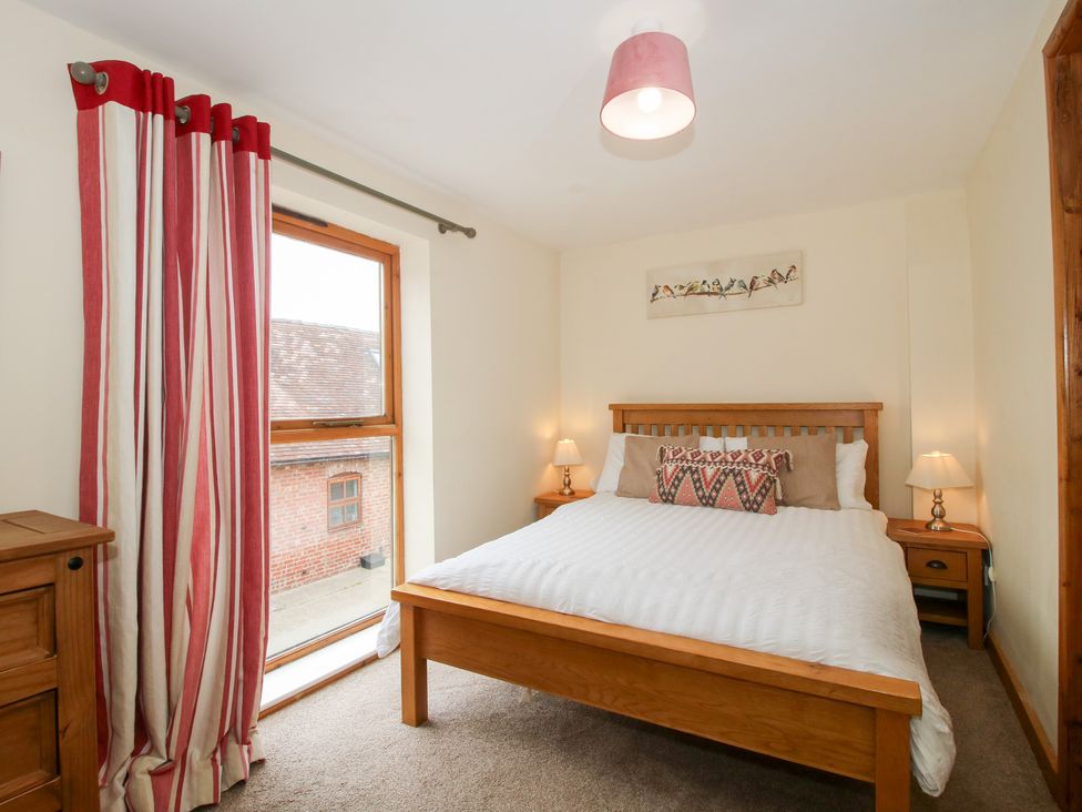 A bedroom with a bed and window at Old Hall Barn 2, Church Stretton