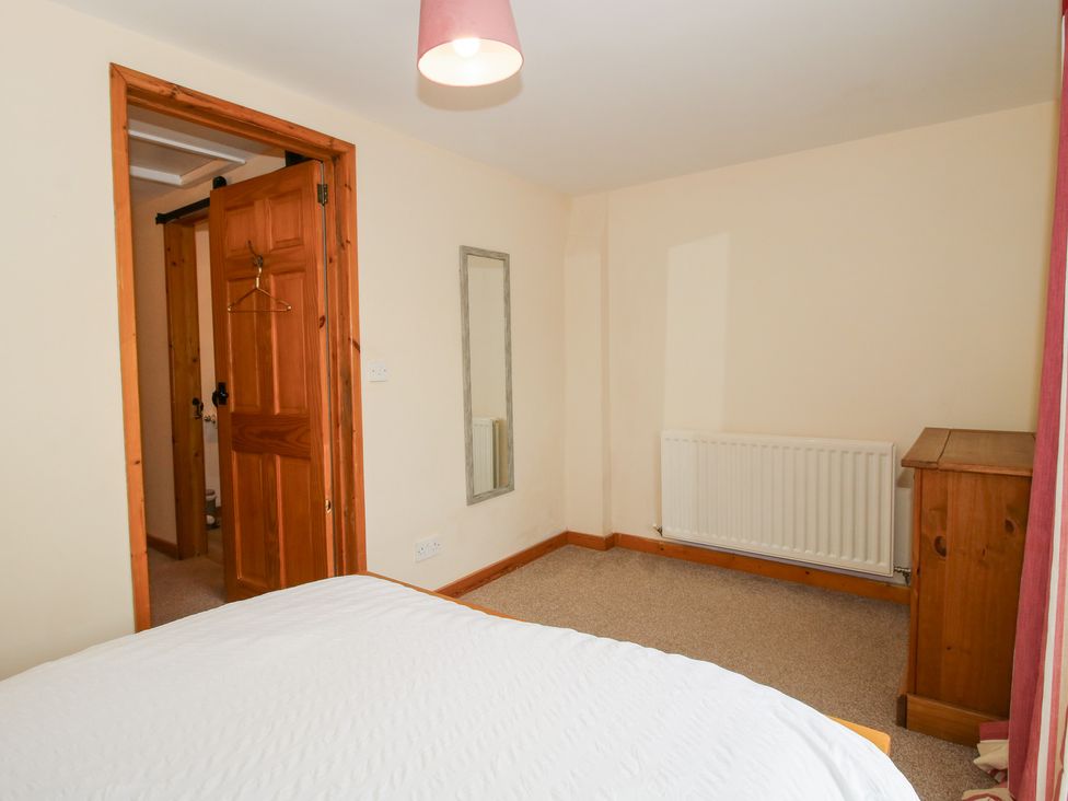 A bedroom with bed, mirror and chest of drawers at Old Hall Barn 2 Church Stretton