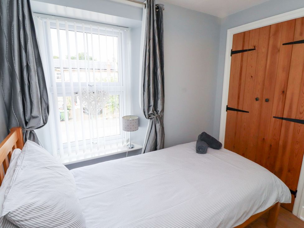 A bedroom with a single bed and lamp at Hasting Dairy North Sunderland near Seahouses