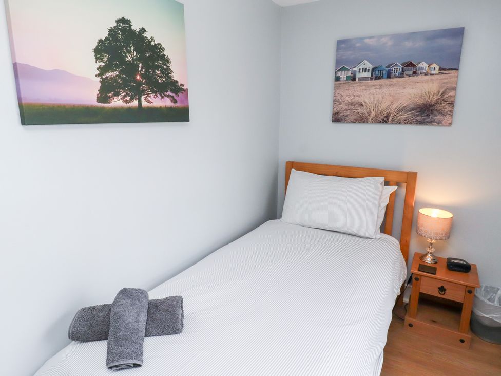 A bedroom with a single bed and wall art at Hasting Dairy North Sunderland near Seahouses