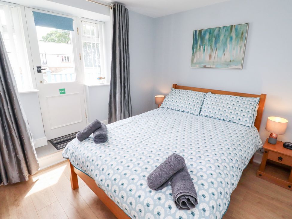 A bedroom with a double bed and door at Hasting Dairy, North Sunderland near Seahouses