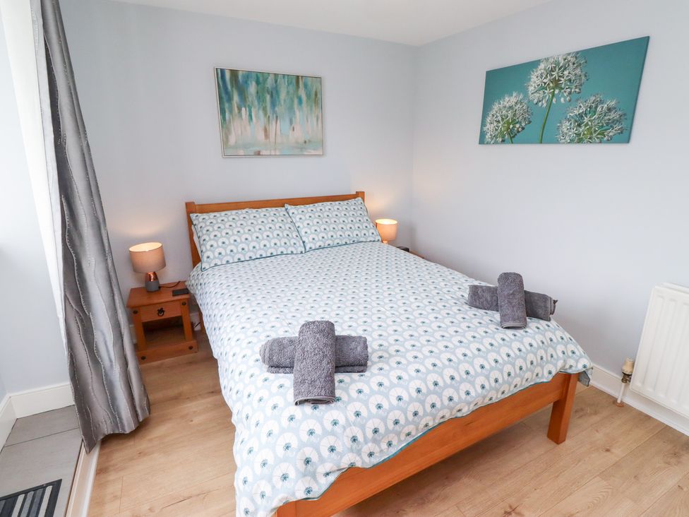 A bedroom with a double bed and bedside table at Hasting Dairy North Sunderland near Seahouses