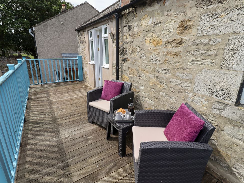 An outdoor seating area with chairs and a small table at Hasting Dairy North Sunderland near Seahouses