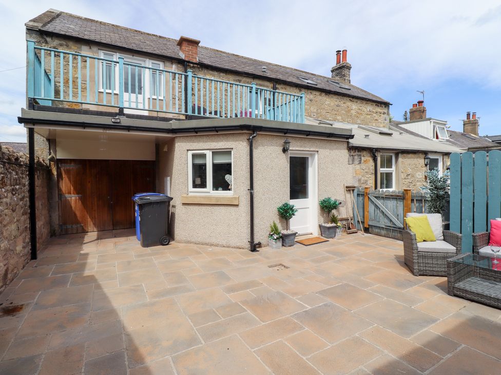 An outdoor area with a balcony and seating at Hasting Dairy in North Sunderland near Seahouses