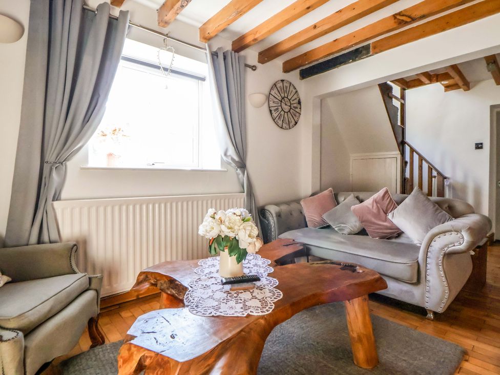 A living room with a coffee table and sofa at Woodland Cottage in Garth