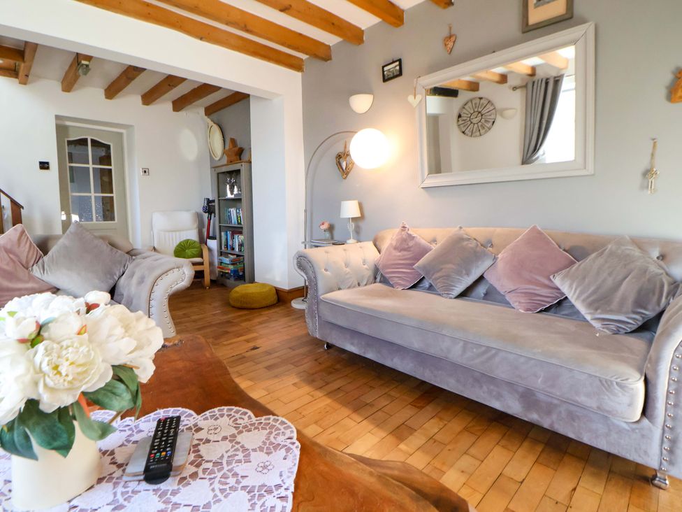 A living room with a sofa and coffee table at Woodland Cottage in Garth