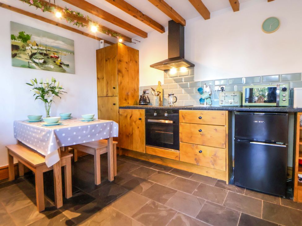 A kitchen with a table and chairs at Woodland Cottage in Garth