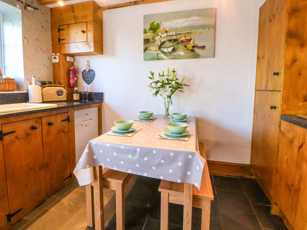 A kitchen with a table set for meals at Woodland Cottage in Garth