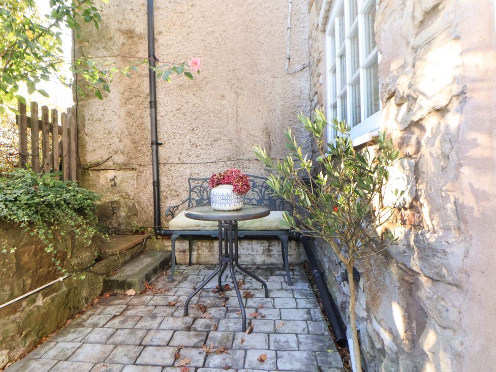 An outdoor seating area with a table and chairs at Woodland Cottage in Garth