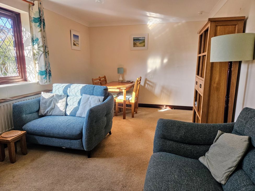 A living room with a sofa and table at Chiffchaff in Padstow