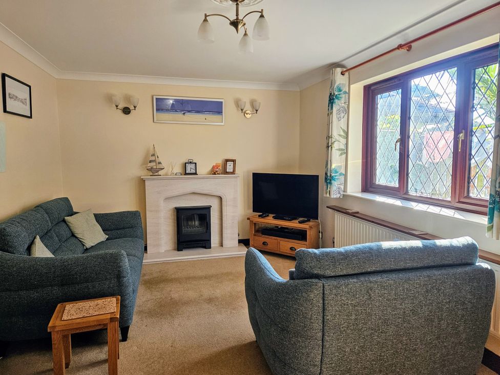 A living room with a fireplace and television at Chiffchaff in Padstow