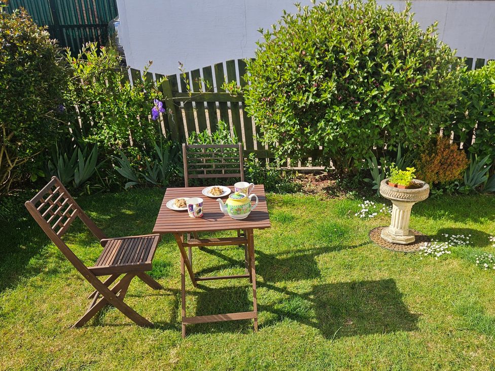 A table with cups and food in a garden at Chiffchaff Padstow