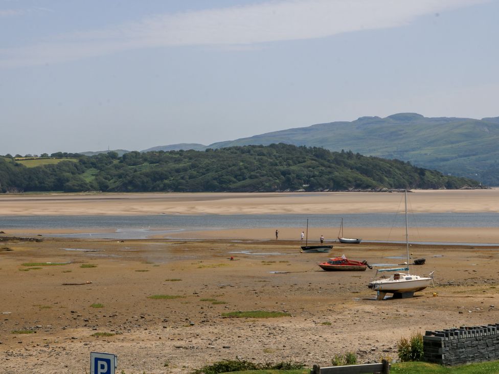A beach scene with boats on sand at Bay View Apartment in Porthmadog