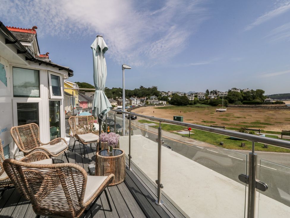 A balcony with chairs and a table at Bay View Apartment in Porthmadog