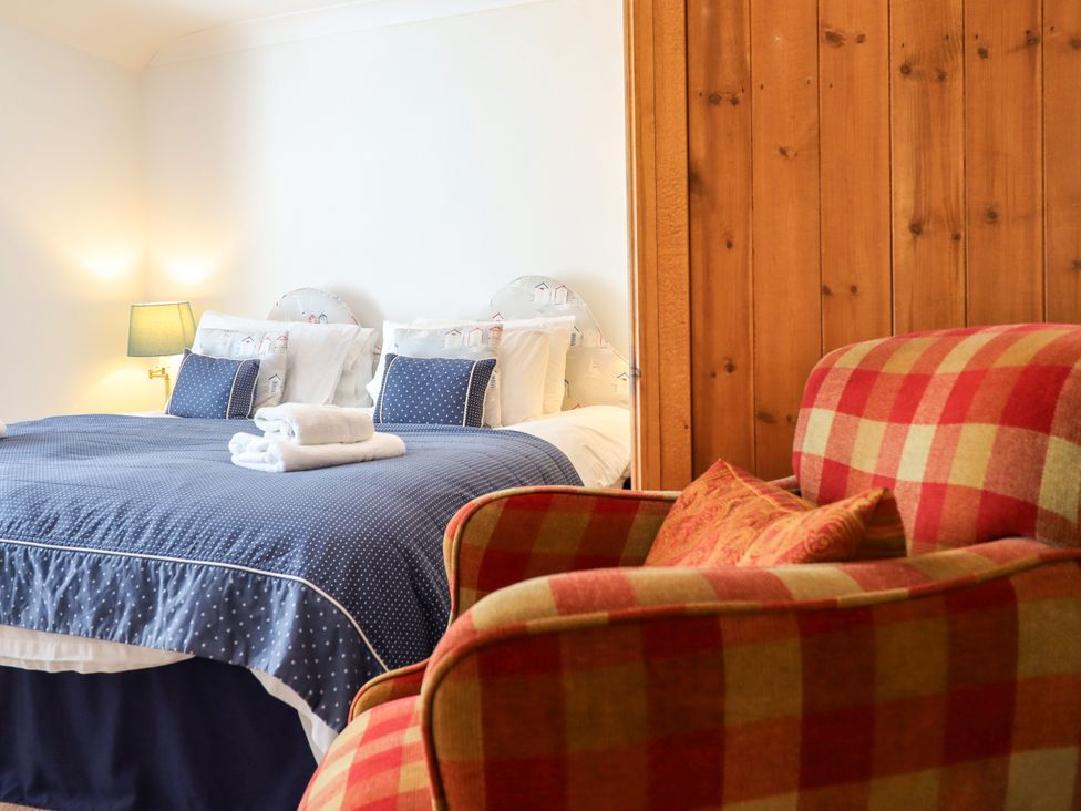 A bedroom with a bed and armchair at Bay View Apartment in Porthmadog