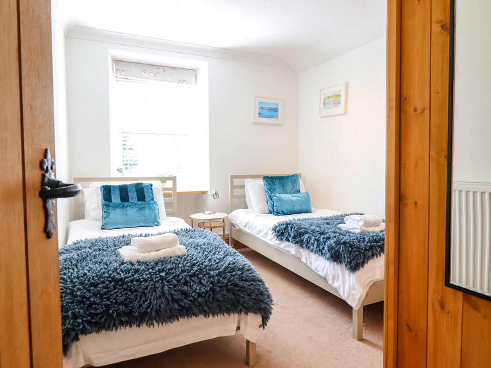 A bedroom with two single beds and a nightstand at Bay View Apartment in Porthmadog