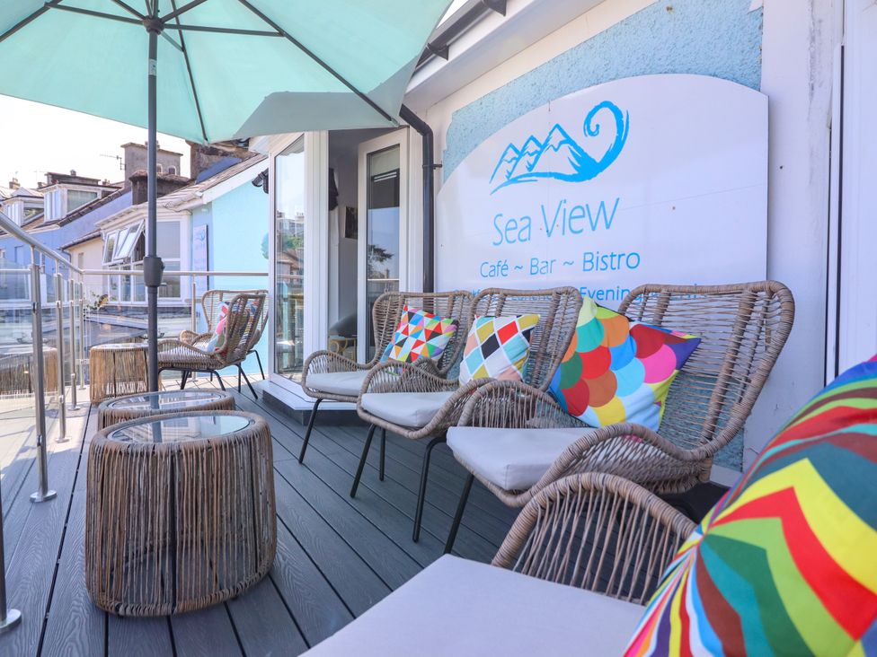 An outdoor seating area with chairs and a table at Sea View Bistro in Porthmadog