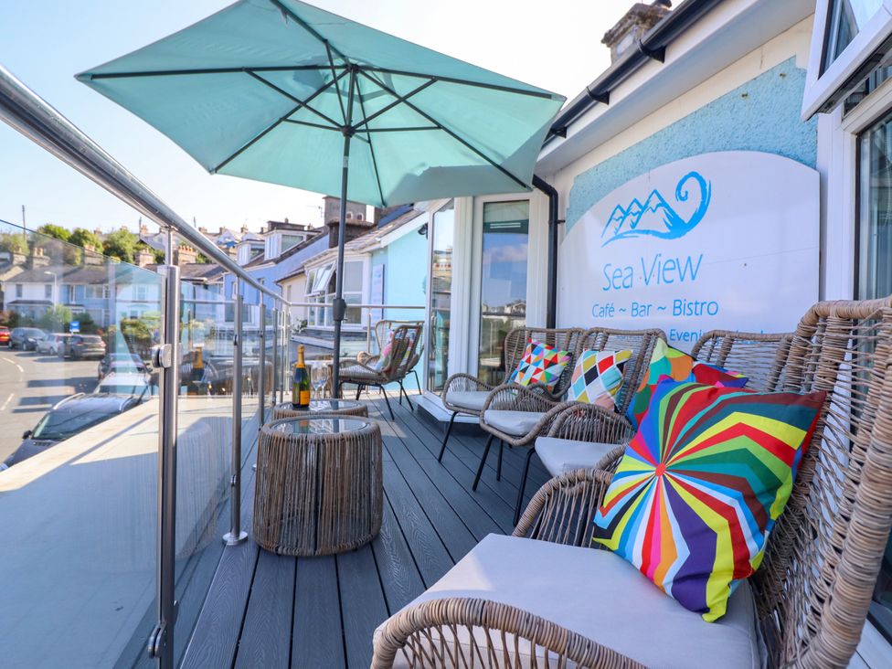 An outdoor seating area with chairs and an umbrella at Bay View Apartment in Porthmadog