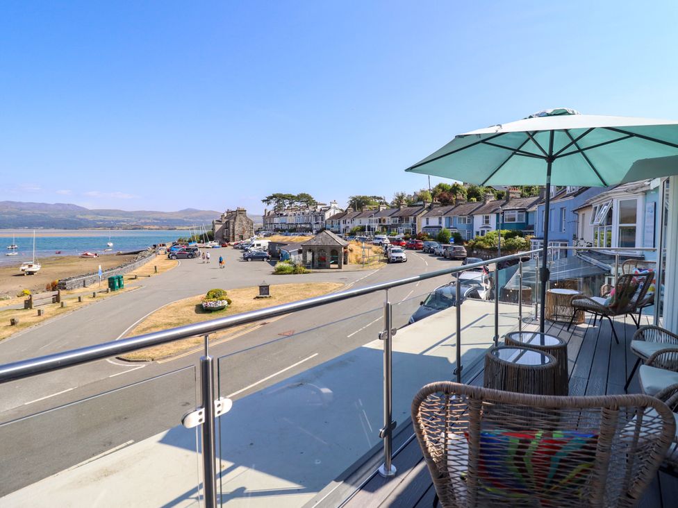 A balcony with a view of the beach and sea at Bay View Apartment in Porthmadog