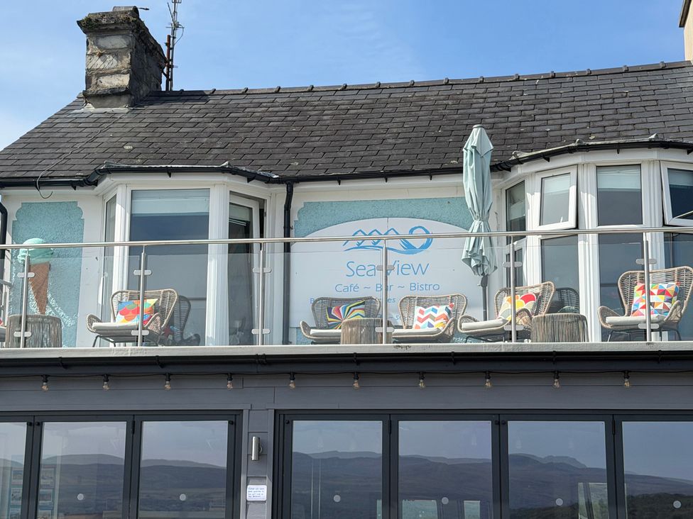 An outdoor seating area with chairs and cushions at Sea View Café Bar Bistro in Porthmadog