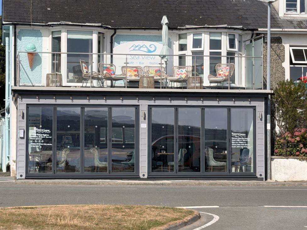 A cafe with outdoor seating and glass windows at Sea View in Porthmadog