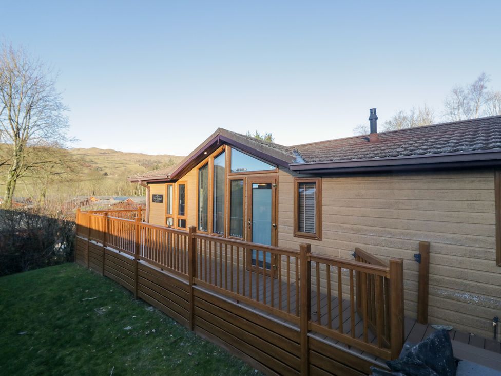 A cabin exterior with a wooden deck and large windows at Heights View