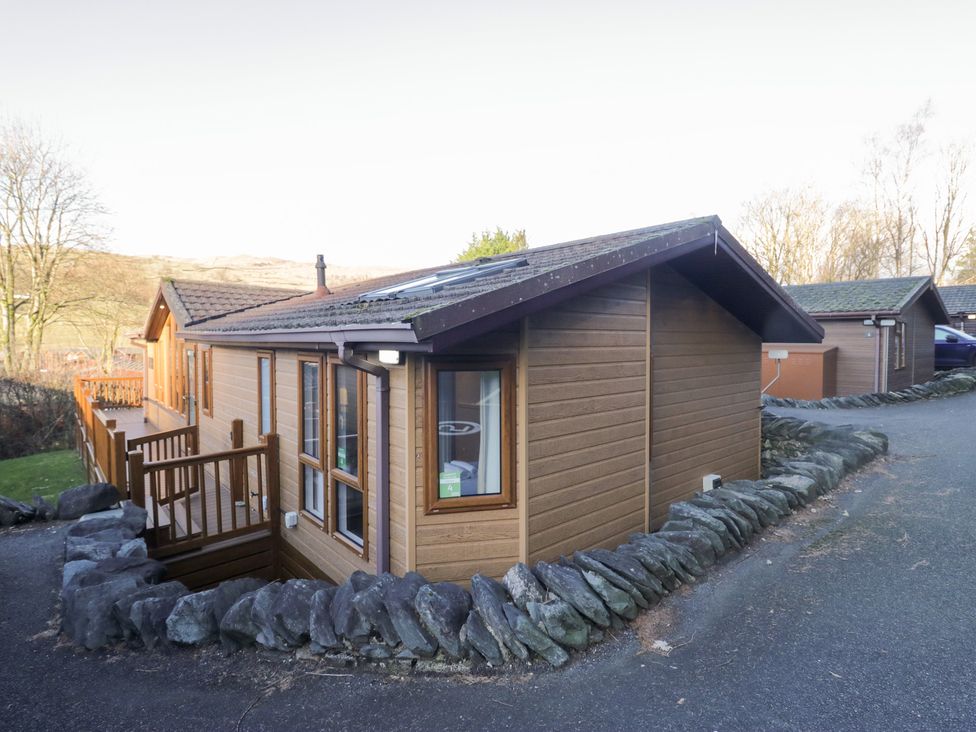A house with a deck and stone wall at Heights View