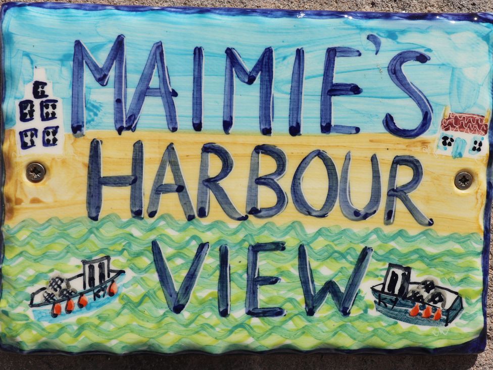 A decorative sign reading Maimie's Harbour View with water and boats illustration