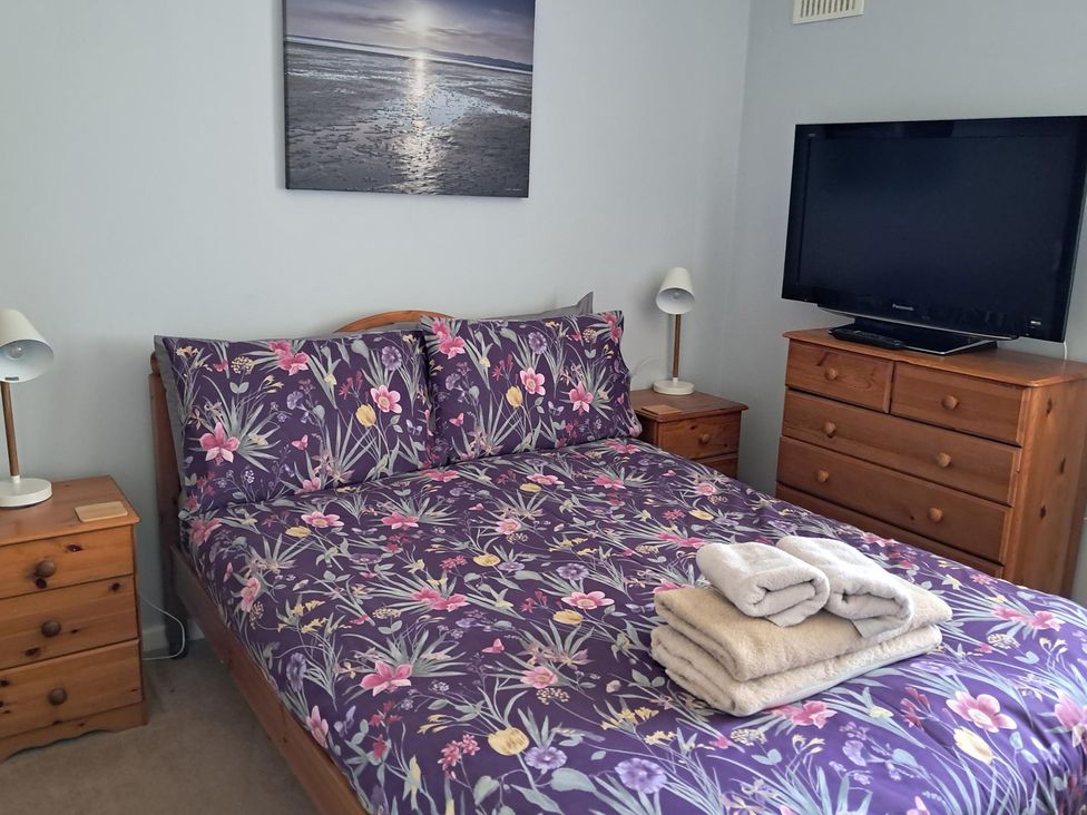 A bedroom with a bed and television at The Lookout -The House With A View Weymouth